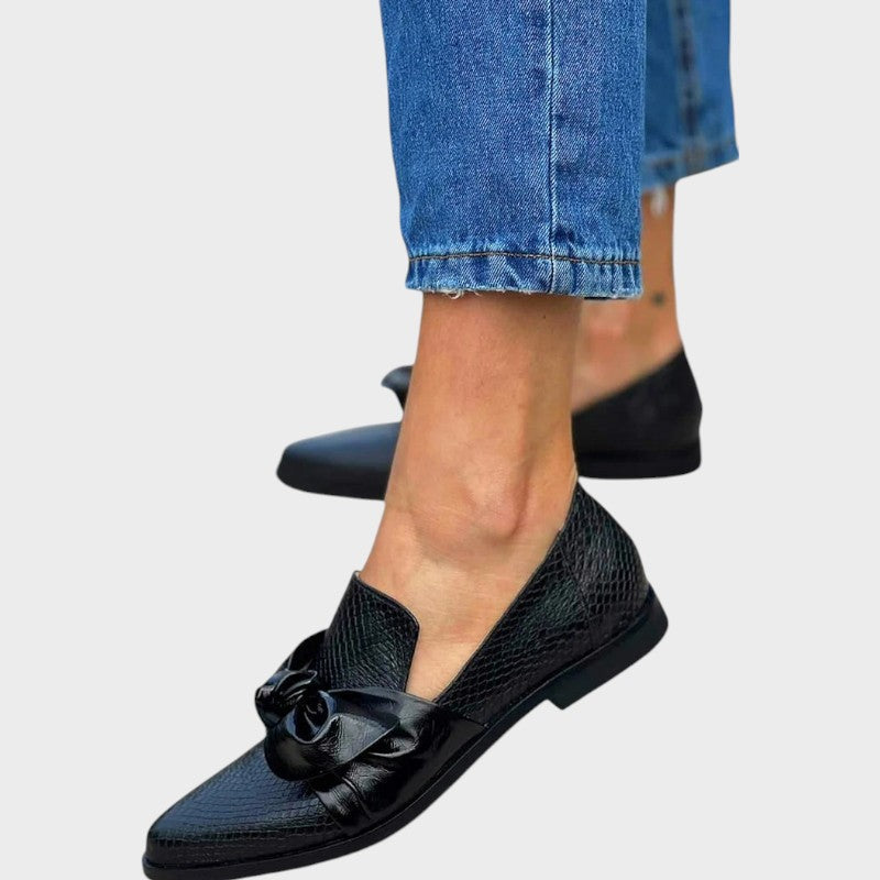 Zinnia – Mocasines Negros con Patrón de Piel de Serpiente y Detalle de Lazo